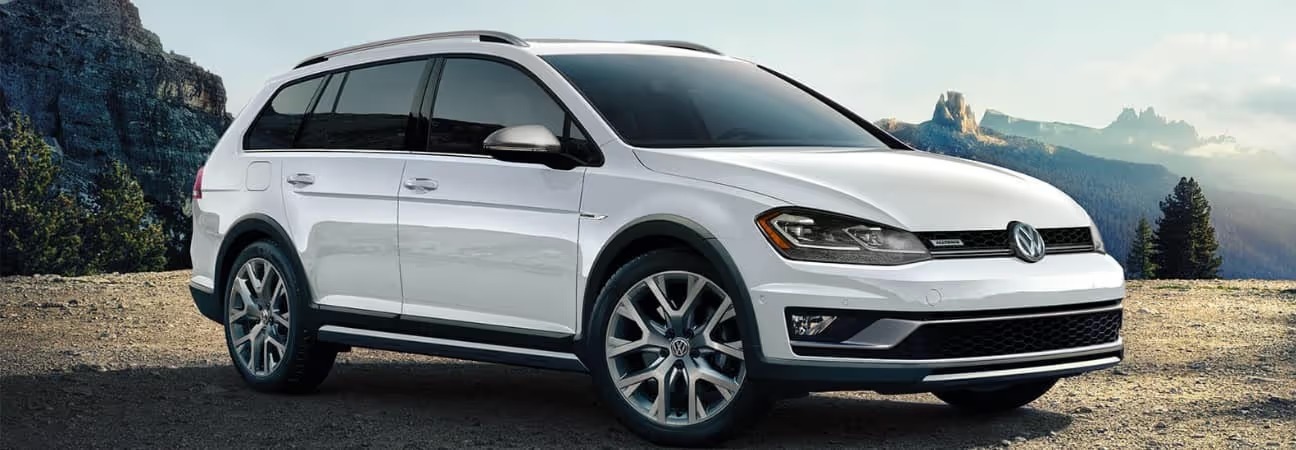 a white 2019 Golf parked off road in front of a mountain range