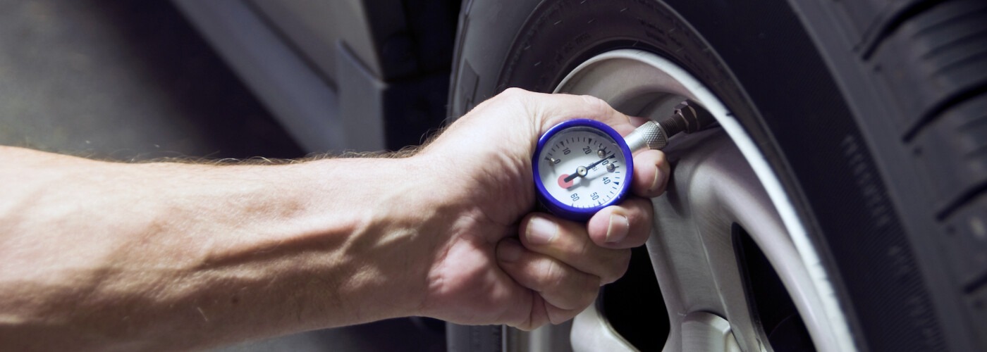 guy checking the pressure of a tire