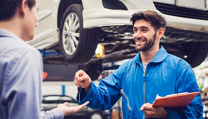 Service technician handing back a client's car keys - Street Volkswagen of Amarillo in Amarillo TX
